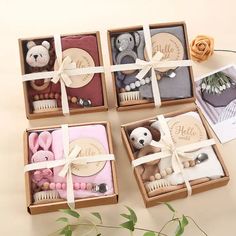 four small boxes filled with assorted items on top of a white table next to a rose