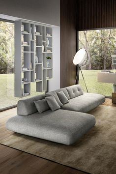 a living room with a large gray couch in front of a book shelf filled with books