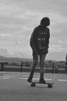 a young man riding a skateboard across a parking lot