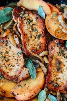 pork chops, onions and mushrooms in a skillet with sage leaves on top