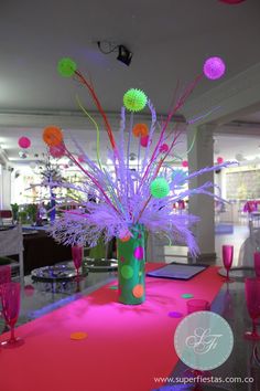 a pink carpeted room with tables, chairs and vases filled with colorful balls