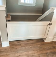 an empty room with wooden flooring and white painted walls in the middle of it