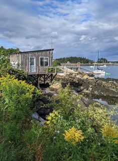 a small house on stilts next to the water