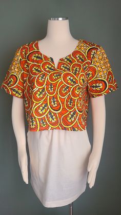 This African print roomy crop top is a great addition your closet. If you just want a splash of color you can keep everything else muted but still bring some vibrancy to your whole outfit. Otherwise go for it by paring it with plain vibrant skirt or pair of pants.  Details: Dropped armholes, boxy fit. Garments Measurements: Crop top: Bust: 42 in                   Waist: 42 in                   Hips: 42 in                   Sleeve Length: 9 in                   Full Length: 18 in Fits:  Medium  B Cotton Cropped Blouse For Vacation, Cropped Cotton Blouse For Vacation, Graphic Print Crop Top For Summer, Summer Cropped Cotton Blouse, Printed Cotton Crop Top For Spring, Bohemian Short Sleeve Crop Top For Spring, Multicolor Cropped Blouse For Spring, Bohemian Short Sleeve Crop Top For Day Out, Floral Print Short Sleeve Crop Top For Vacation