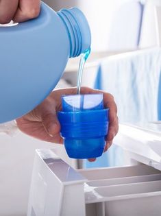 a person pouring water into a blue cup