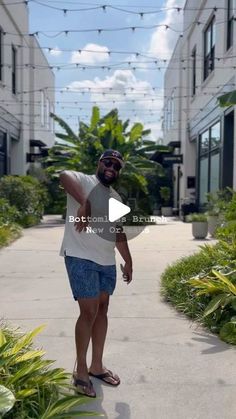 a man is standing on the sidewalk pointing at something