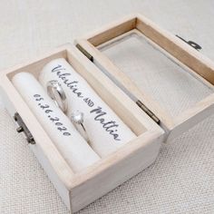 two wedding rings in a wooden box with writing on the inside, and an empty ring case