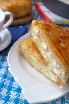 two pieces of pastry on a plate next to a cup of coffee