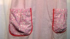 a pink and white checkered apron hanging on a wall