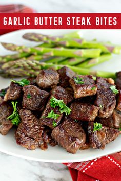 garlic butter steak bites on a plate with asparagus