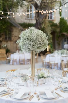 a table is set with white linens and place settings