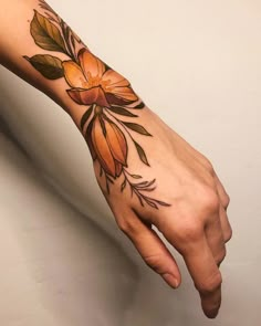 a woman's hand with a flower tattoo on the left wrist and right arm