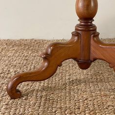 a wooden table with a glass top on carpeted floor