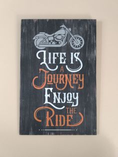 a wooden sign that says life is a journey enjoy the ride on a motorbike