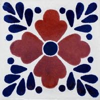 a red and blue flower design on a white tile wall with water drops in the center