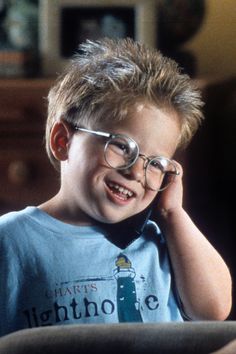 a young boy wearing glasses sitting at a table