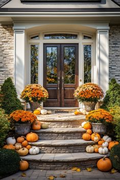 a front door with pumpkins and gourds on the steps