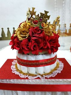 there is a cake that has been decorated with red roses and gold crown on top