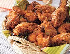 a basket filled with fried chicken on top of a table