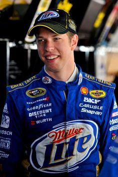 a man in a blue racing suit and hat