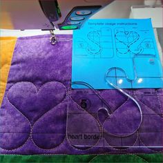 the sewing machine is next to some purple material with hearts on it and a blue piece of paper that says heart border