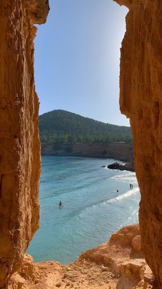 people are swimming in the ocean through some rocks