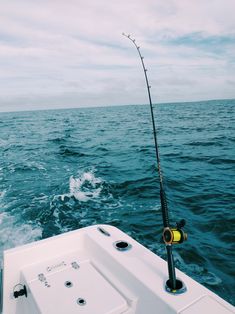 a fishing rod on the back of a boat in the ocean with water behind it