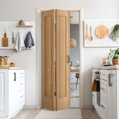 an open wooden door in a white kitchen