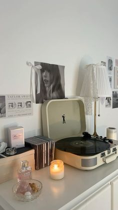 a record player sitting on top of a table next to a lamp and some pictures