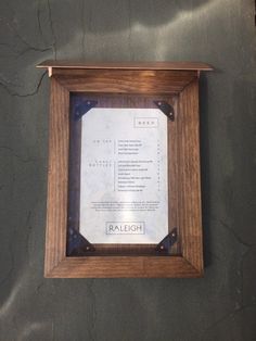 a wooden frame hanging on the wall above a menu