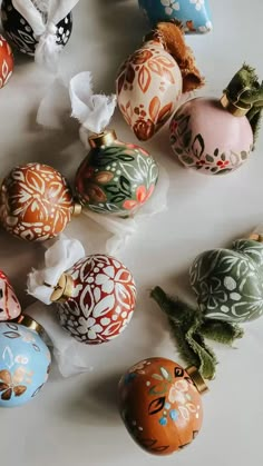 an assortment of painted christmas ornaments on a table