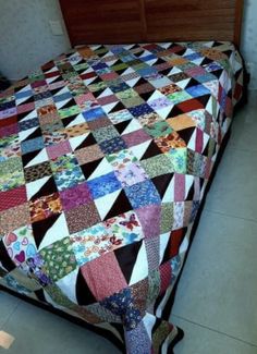 a bed with a colorful quilt on top of it