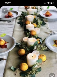 the table is set with candles and oranges