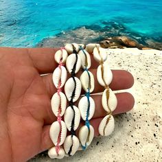 "Embrace the essence of the ocean with our handcrafted Cowry Shell Bracelet/Anklet. Each piece is a symphony of natural elegance, featuring authentic cowry shells that have been carefully selected for their unique beauty. These shells, treasured for centuries as symbols of prosperity and good luck, now adorn your wrist or ankle in a dance of bohemian charm. Our versatile design allows for an adjustable fit, ensuring that you can wear it comfortably as a bracelet or anklet, making it the perfect Adjustable Coastal Jewelry For Vacation, Adjustable Coastal Style Jewelry For Vacation, Adjustable Shell Bracelets With Ocean-inspired Style, Adjustable Ocean-inspired Shell Bracelets, Vacation Beaded Bangle Jewelry, Adjustable Strand Jewelry With Sliding Knot, Shell Bracelet For Beach Season, Shell Bracelet For Beach, Shell Bracelet Jewelry For Beach