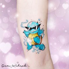 a small tattoo on the leg of a person with a blue and yellow pokemon character