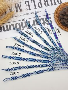 six blue and white paper straws sitting on top of a table next to a pine cone