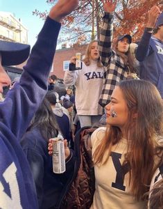 a group of young people standing around each other holding up their cell phones in the air