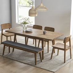 a dining room table with four chairs and a bench in front of it, next to a window