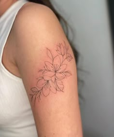 a woman's arm with a flower tattoo on the left side of her arm