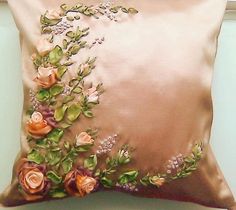 an embroidered pillow with flowers on it