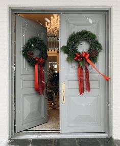 two wreaths on the front doors of a building