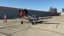 a small plane sitting on top of an airport tarmac next to a man walking