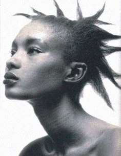 a black and white photo of a woman with dreadlocks on her head looking off to the side