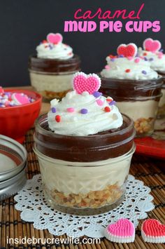 small desserts in glass jars with hearts on the top are ready to be eaten