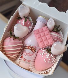 a pink box filled with assorted chocolate covered strawberries and marshmallows