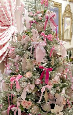 a decorated christmas tree with pink bows and ornaments