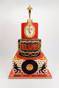 a three tiered cake with an elvis theme on it's side and a record in the middle