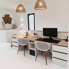 a desk with two chairs and a computer on top of it in a white room