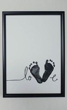 two framed pictures hanging on the wall with baby's feet and handprints