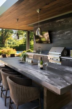 an outdoor kitchen with grill and bar stools